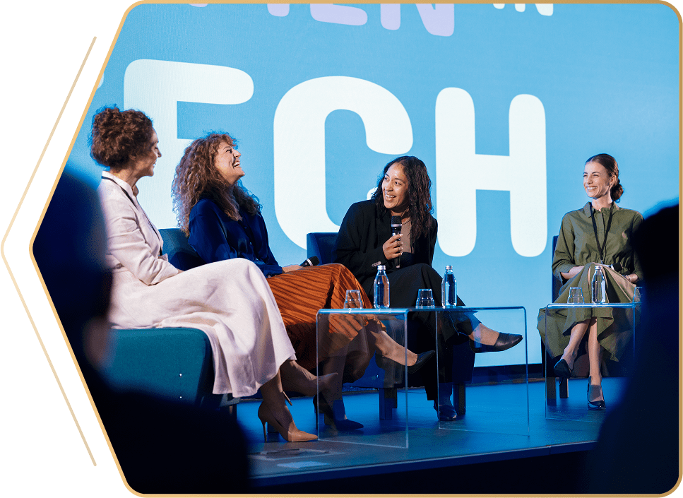 Women panelists discussing technology on stage